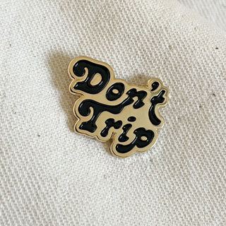 Don't Trip Enamel Pin black and gold on a white background - Free & Easy